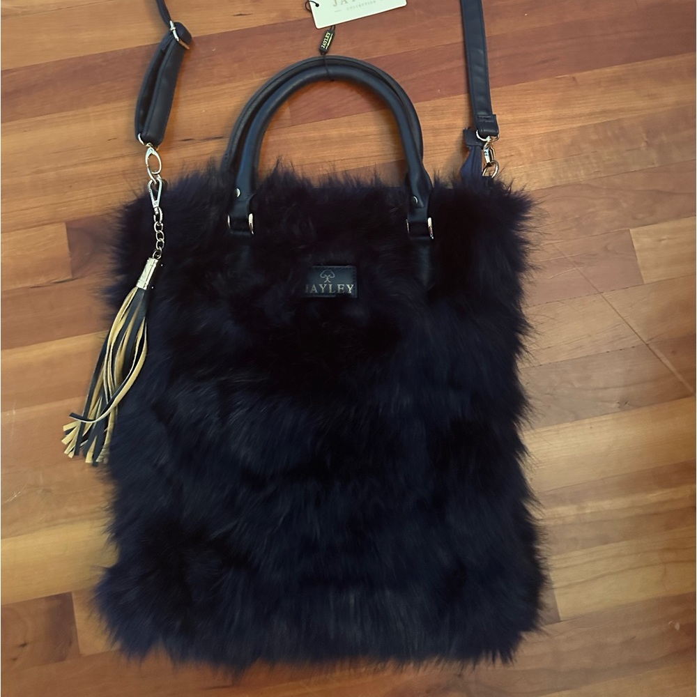 Faux fur navy purse with tassel and shoulder strap and handles.